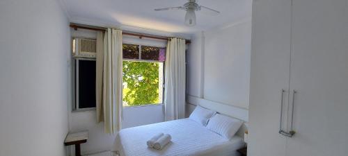 Habitación blanca con cama y ventana en COGRA0100 - Muito verde pertinho do Shopping Barra, en Salvador