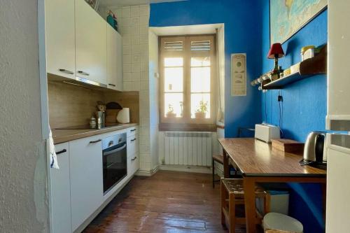 een keuken met blauwe muren en een tafel en een raam bij La Cristina in Berástegui