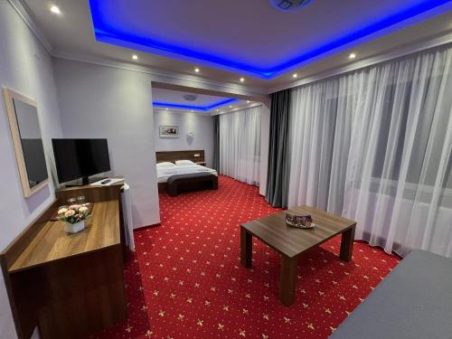 a hotel room with a bed and a red carpet at Vila Cristal in Baile Felix