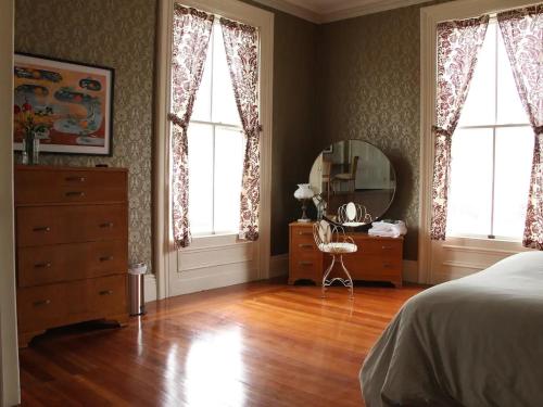 a bedroom with a bed and a dresser and a mirror at The Wedding Cake House in Providence