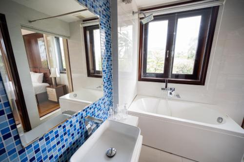 a bathroom with a tub and a sink and a mirror at Fuse Old Town Hoi An in Hoi An