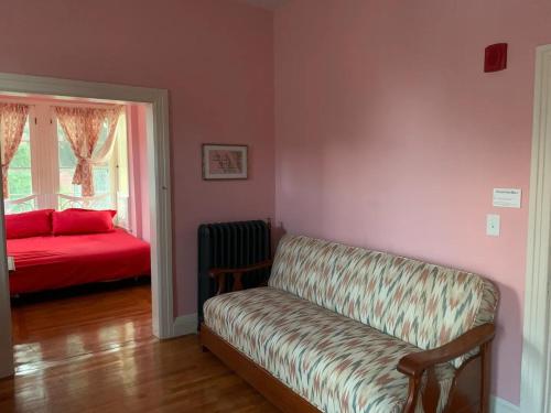 a living room with a couch and a red bed at The Wedding Cake House in Providence