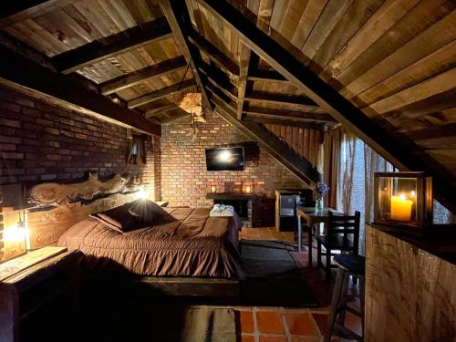 a bedroom with a large bed in a brick wall at El Agrado Restaurante Cabañas in Líbano