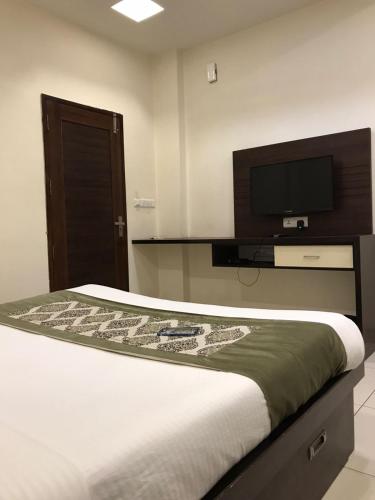 a bedroom with a bed and a flat screen tv at Hotel Fortune Plaza in Ajmer