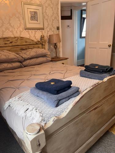 two towels sitting on top of a bed at Harbour View Ground Floor Flat with Private Parking, only 5 Mins walk to harbour in Brixham