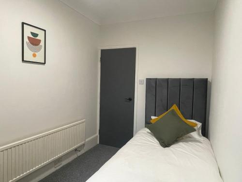 a bedroom with a bed with a black headboard at Woodford Hotel in London