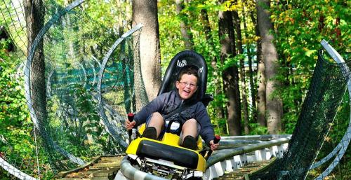 a young boy is riding a ride on a toy motorcycle at The Lodge at Wisp in McHenry