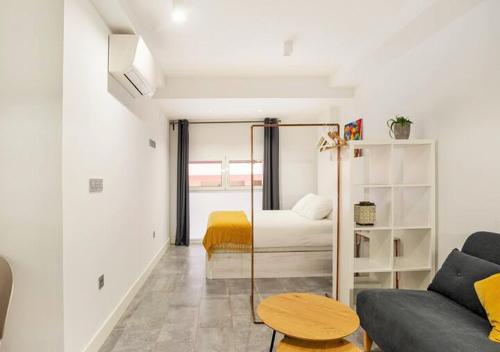 a living room with a bed and a couch at LoftinMalaga in Málaga