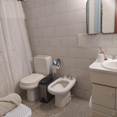 a white bathroom with a toilet and a sink at La Glicina casa in La Plata