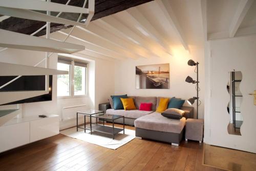sala de estar con sofá y TV en Duplex de charme avec terrasse aux portes de Paris, en Saint-Germain-en-Laye
