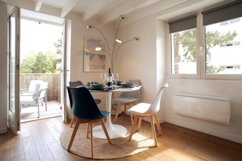 ein Esszimmer mit einem Tisch und Stühlen in der Unterkunft Duplex de charme avec terrasse aux portes de Paris in Saint-Germain-en-Laye