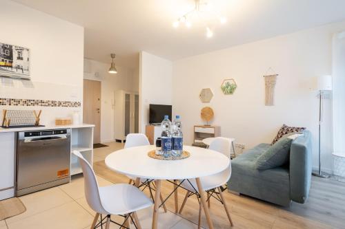 Una cocina y una sala de estar con una mesa y un sofá. en Love Live Łódź z ogrodem, Parking, Grill, en Łódź