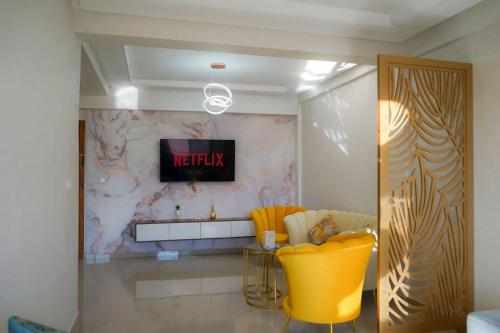 a living room with yellow chairs and a television at Most Beautiful Apartment in Safi in Safi