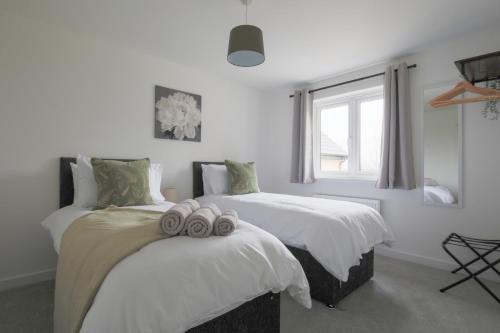 1 dormitorio con 2 camas y toallas. en StayRight 4 Bedroom, 3 Bathroom House Near M4 - 15 mins to Cardiff & Newport, en Cardiff