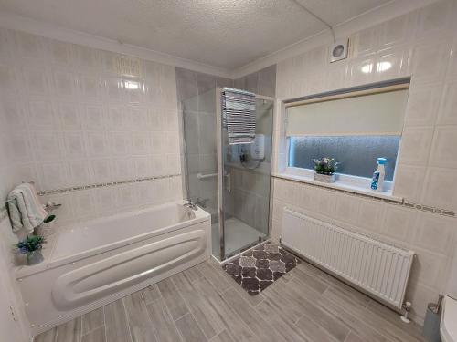 a bathroom with a bath tub and a shower at Seaview Cottage Dugort Achill Island in Doogort