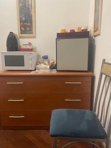 un forno a microonde seduto sopra un comò in legno di bb Nuova Fiera di Roma a Porto