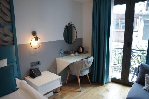 a small room with a desk and a window at Royal Galata Hotel in Istanbul
