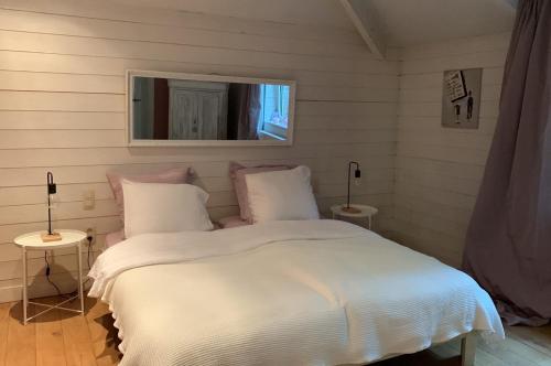 1 dormitorio con 1 cama blanca y 2 mesas en Villa Carpay en Louveigné