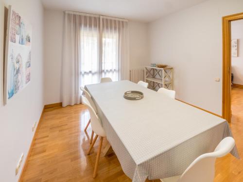 a white dining room with a white table and chairs at Gestión de Alojamientos Apartments in Pamplona