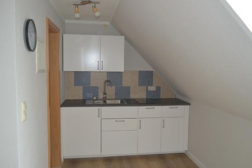 a kitchen with white cabinets and a sink at Haus Simone in Insel Poel