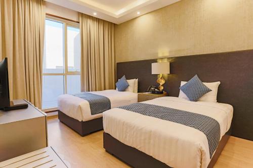 a hotel room with two beds and a television at Sarwat Park Hotel Riyadh - Diplomatic Quarter in Riyadh