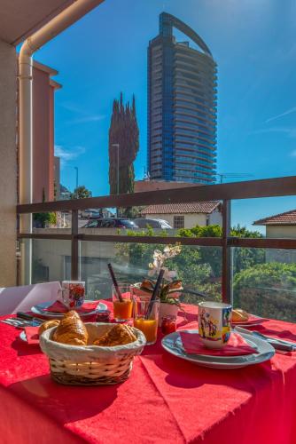 une table avec un tissu de table rouge et de la nourriture dans l'établissement Monaco Sea View & Parking, à Beausoleil