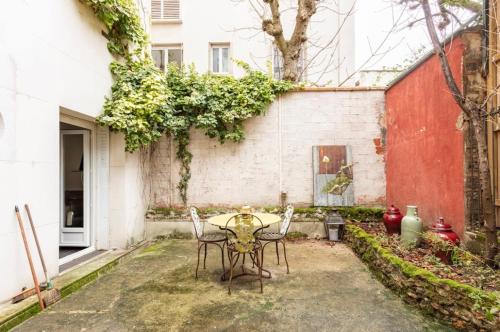 a table and chairs in front of a building at apartment with garden in Neuilly-sur-Seine