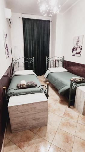a room with two twin beds and a chandelier at Home Sweet Home COSENZA in Cosenza