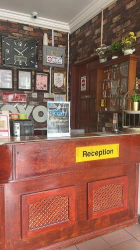 Eine Bar mit einem gelben Schild, auf dem der Empfang steht. in der Unterkunft Sri Seroja Inn Hotel in Kota Bharu