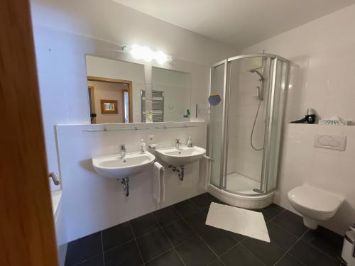 a bathroom with two sinks and a shower and a toilet at Lovely 3 Bedroom Apartment, Ski in/Ski out in Obertauern