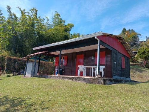 a small house with two white chairs in a yard at Marina Navegar in Guatapé