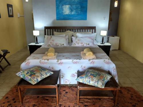 a bedroom with a large bed with towels on it at Sítio Maleleo in Porto De Galinhas