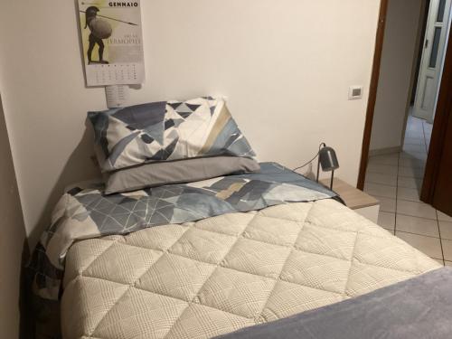 a bed with a comforter and pillows in a bedroom at Bed and Breakfast da Giuseppe, Camere vicino stabilimento Ferrari in Fiorano Modenese
