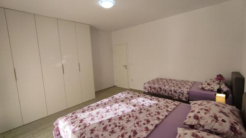 a bedroom with two beds with pink sheets and a door at Apartmani Juresko Mrljane in Mrljane