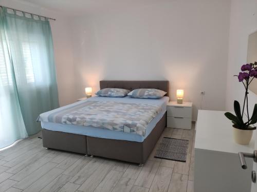 a bedroom with a bed with two lamps on it at Apartmani Juresko Mrljane in Mrljane