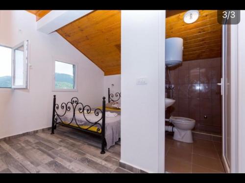 ein Schlafzimmer mit einem Bett und einem WC in einem Zimmer in der Unterkunft Skadar Lake Family Resort in Rijeka Crnojevića