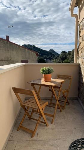 une table en bois et deux chaises sur un balcon dans l'établissement Résidence Casa Olea - Studio - T2 - T3, à Cauro