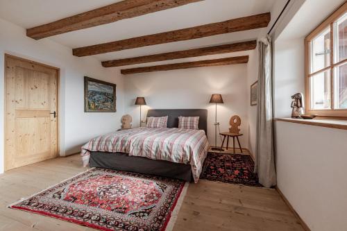 a bedroom with a bed with a rug and a window at Haus Sophie in Longostagno
