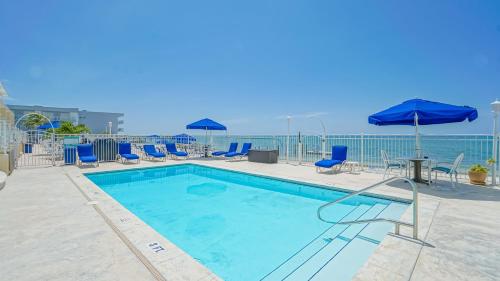 a swimming pool with chairs and tables and umbrellas at Glunz Ocean Beach Hotel and Resort in Marathon