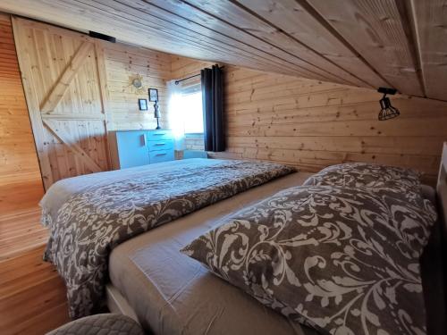 a bedroom with two beds in a log cabin at Zbychówko in Zbychowo