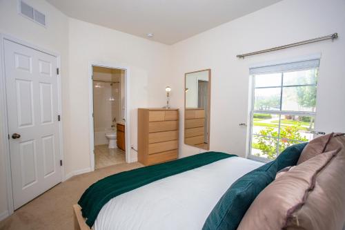 een slaapkamer met een bed en een badkamer met een raam bij Four Bedrooms Townhouse 4563 in Kissimmee