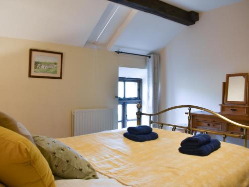een slaapkamer met een bed met blauwe handdoeken bij Oaktree Cottage-uk42227 in Low Borrowbridge