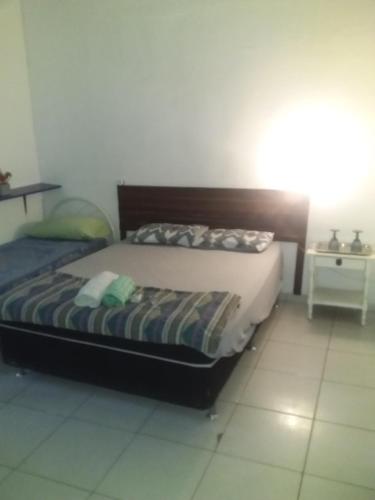 ein Schlafzimmer mit einem Bett in einem Zimmer in der Unterkunft Pousada do Alex in Campos dos Goytacazes