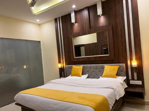 een slaapkamer met een groot bed met gele kussens bij Hotel Sukoon Bharatgarh in Rūpnagar