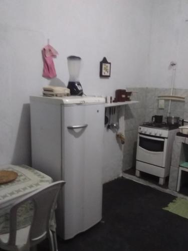 a kitchen with a stove and a white refrigerator at Pousada Lírio in Campos dos Goytacazes