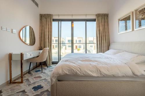 a bedroom with a bed and a desk and a window at Al Dana Sea View Villa in Fujairah