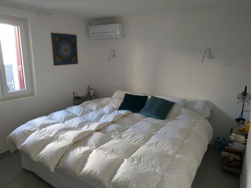 een groot wit bed in een kamer met een raam bij Port love in Port-Vendres