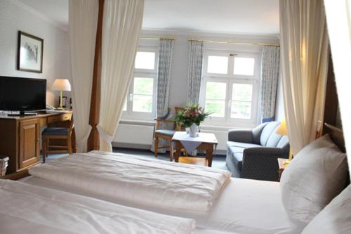 a bedroom with a bed and a living room at Hotel Alter Packhof in Hannoversch Münden