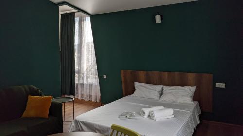 a bedroom with a bed with towels on it at Lagaza's - Home in Tbilisi City