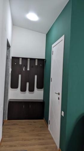 a locker room with two baseball pads and a green wall at Lagaza's - Home in Tbilisi City